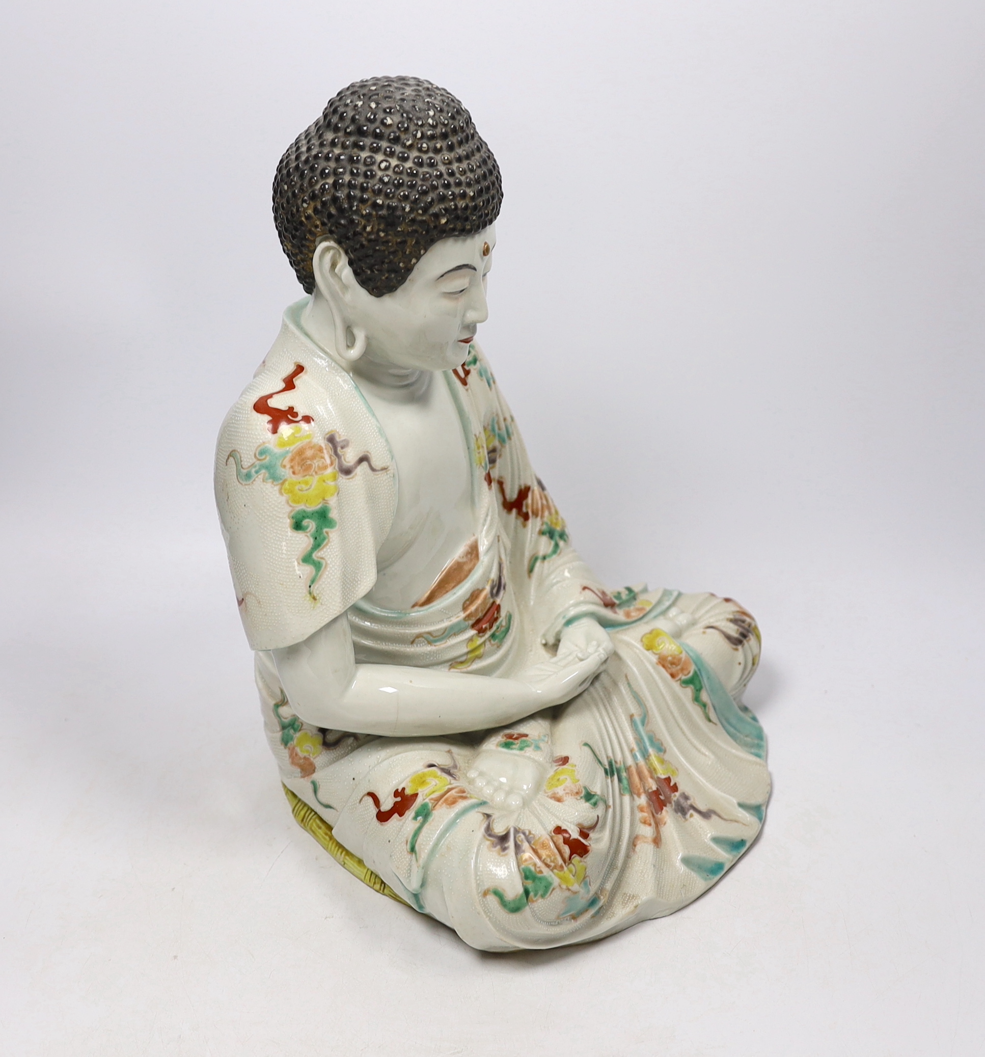An early 20th century Chinese or Japanese enamelled porcelain figure of Buddha, 33cm